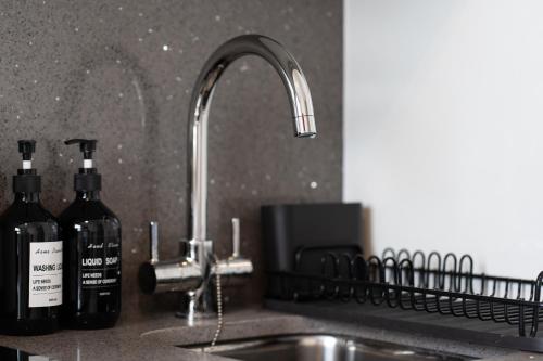 two bottles of wine are sitting next to a kitchen sink at Boutique Studios by Luxestays Fulham Broadway in London