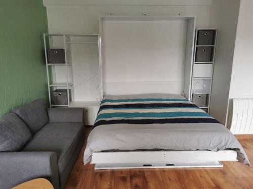 une chambre avec un lit et un canapé dans l'établissement Studio Coatserho, à Lorient