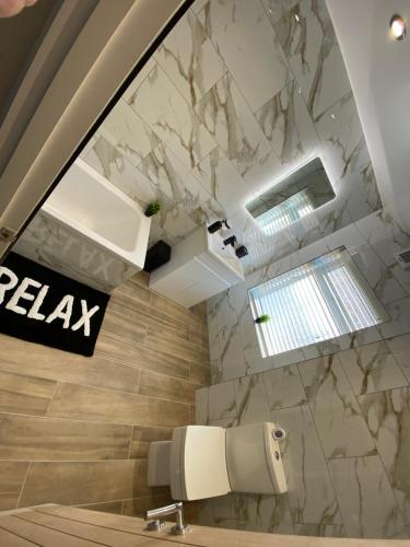 a bathroom with a marble wall and a sink at Marine Cottage 2 - With Private Hot Tub in Newbiggin-by-the-Sea