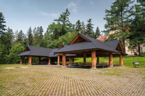 a pavilion with a black roof in a park at Rewita Kościelisko-Zakopane in Kościelisko