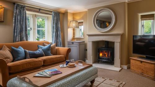 Una sala de estar con un sofá y una chimenea. en Otmoor House, en Beckley
