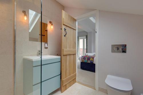 a bathroom with a sink and a toilet and a bed at Beresford House in Wells next the Sea