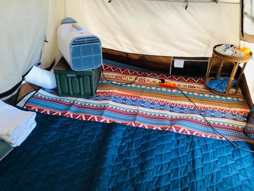 a bed in a tent with a fan on it at Cóc Retreat Mỹ Tho City in My Tho