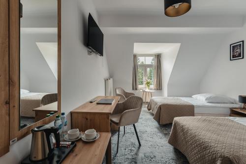 a bedroom with two beds and a desk and a mirror at Rewita Kościelisko-Zakopane in Kościelisko