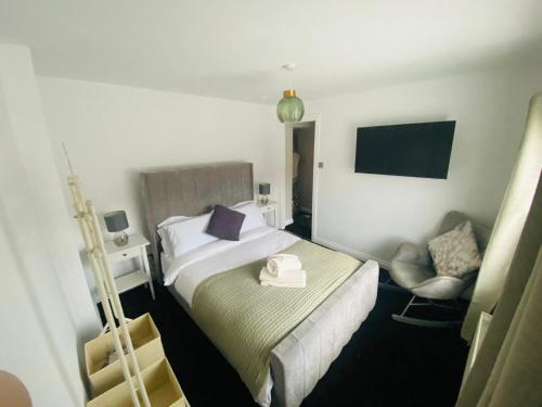 a hotel room with a bed and a chair at Marine Cottage 2 - With Private Hot Tub in Newbiggin-by-the-Sea