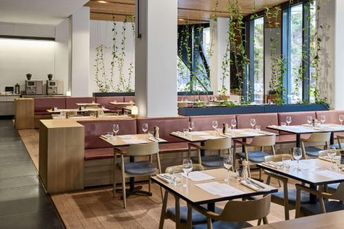 a restaurant with tables and chairs and a bar at Vibe Hotel Melbourne Docklands in Melbourne