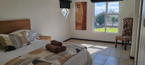 a bedroom with a large bed and a window at Klipvis at Duykereiland in St Helena Bay