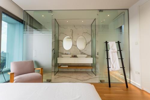 a bathroom with a sink and two mirrors at Ocean Blue in Paphos City
