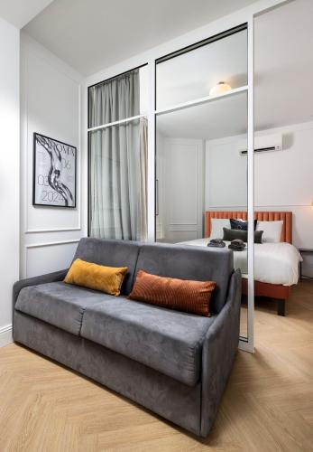a living room with a couch in front of a bed at New Center Easy Access Balcony in Monte Carlo