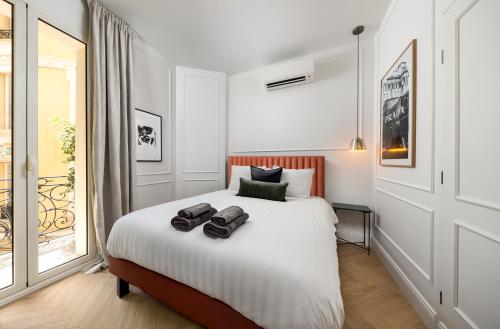 a bedroom with a bed with two shoes on it at New Center Easy Access Balcony in Monte Carlo