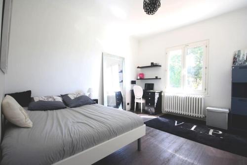 a bedroom with a bed and a desk and a window at Spacious villa for family holidays in Valbonne