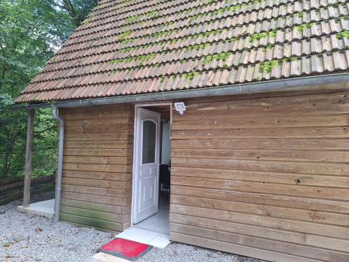a wooden shed with a white door and a roof at gite tipi in Faux-la-Montagne