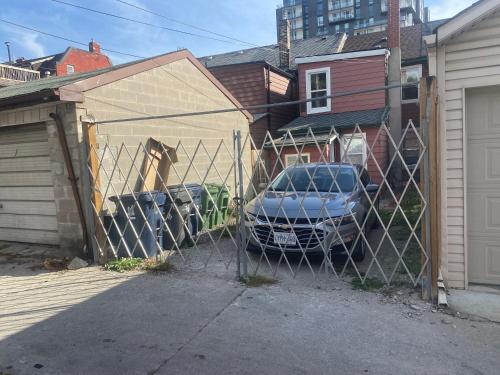 a fence with a car parked in a garage at BUDGET Quad Room with En Suite Bathroom 36B in Toronto