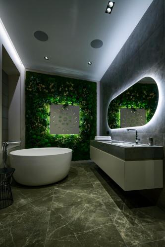a bathroom with a tub and a green wall at Luxury Smart Home Apartment in Vilnius Old Town, Sleep on Hästens in Vilnius