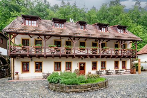a building with windows and balconies in a courtyard at Černodolský mlýn in Chotiměř