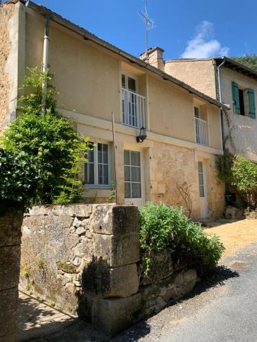 una vieja pared de piedra frente a un edificio en La Maison Colette, en Les Eyzies-de-Tayac