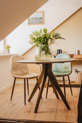 a dining room table with a vase of flowers on it at La Fornaccia in Anloo