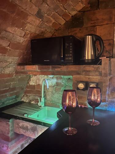 two wine glasses sitting on a counter in a kitchen at Vinný sklep Klentnice in Klentnice