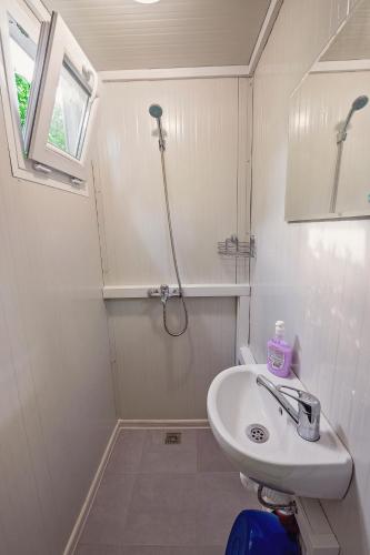 a white bathroom with a shower and a sink at Каравани AVI IRIS Фичоза in Varna City