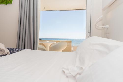 a bedroom with a bed and a view of the ocean at White Bay in Fontane Bianche