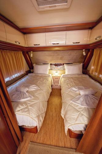 two beds in the middle of a small room at Каравани AVI IRIS Фичоза in Varna City