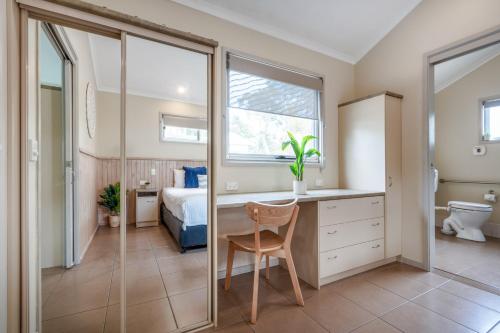 a bedroom with a desk and a bed and a window at BIG4 Tasman Holiday Parks - Ballina in Lennox Head