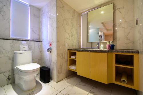 a bathroom with a toilet and a sink and a mirror at Olah Poshtel Taichung Wenxin in Taichung