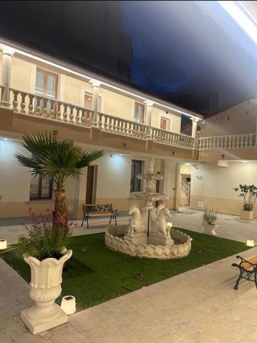 a large building with a fountain in a courtyard at Hôtel du Parc Canal - Stade de France in Saint-Denis