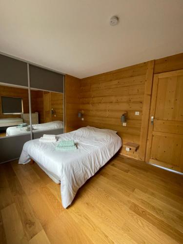 une chambre avec un grand lit et des murs en bois dans l'établissement La remise, à Beaune