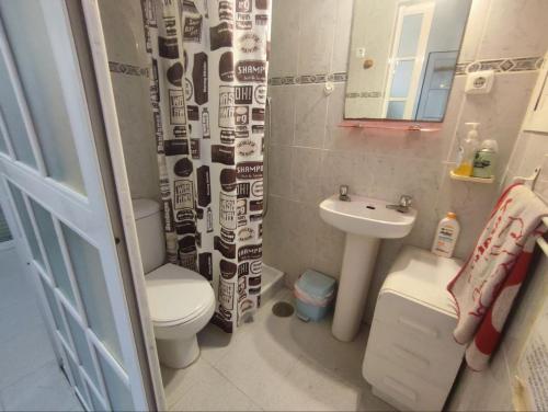 a small bathroom with a toilet and a sink at Casa Athenea in Conil de la Frontera