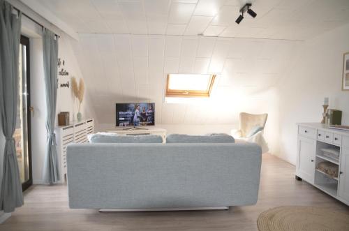 a white living room with a couch and a tv at Ferienwohnung Brehm in Bad Staffelstein