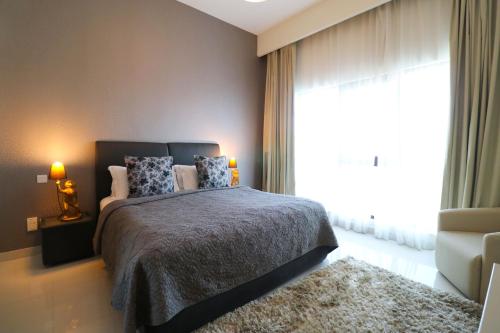 a bedroom with a bed and a large window at Lagoona Beach Luxury Resort and Spa in Manama