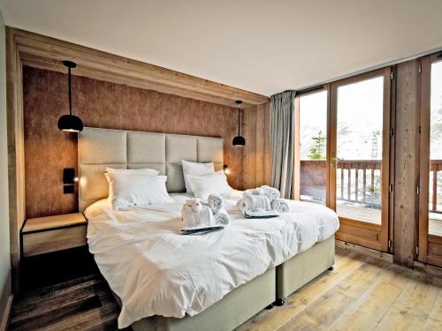 una camera da letto con un grande letto con due piatti sopra di Chalet familial 12 pers avec jacuzzi et ski-in/ski-out - FR-1-613B-40 a Les Bruyères