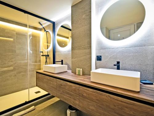 un bagno con due lavandini e uno specchio di Chalet familial 12 pers avec jacuzzi et ski-in/ski-out - FR-1-613B-40 a Les Bruyères