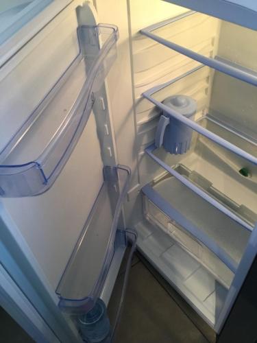 an empty refrigerator with its door open with its at Le Sérènity in Le Landin
