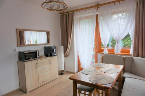 Nad Strumyczkiem - pokoje gościnne - Apartamenty z przymróżeniem oka في شتوروك: غرفة معيشة مع طاولة وأريكة