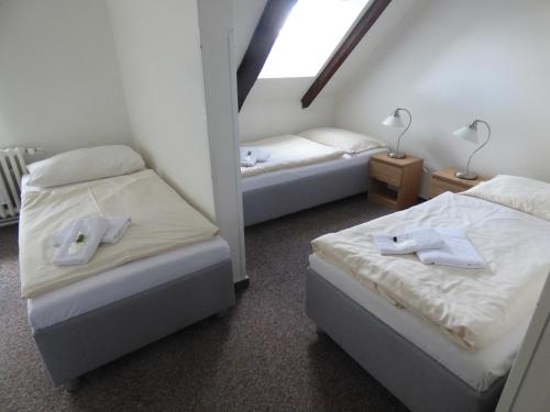 a room with two beds with towels on them at Hotel Svornost in Prague