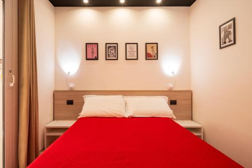 a bedroom with a red bed with two lights at Affittacamere Casa Concia in Tortolì
