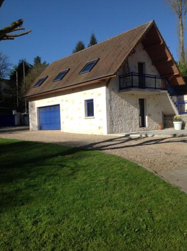 a house with a garage with a roof at Le Sérènity in Le Landin