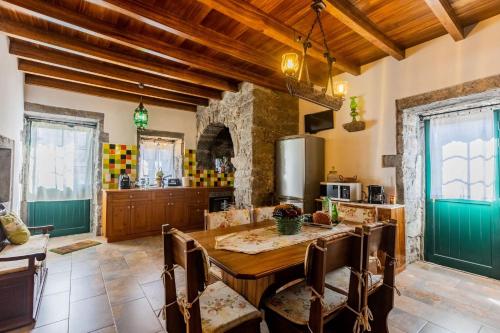a kitchen with a wooden table in a room at Charming green country house in Laseira