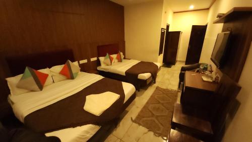 a hotel room with two beds and a television at Hotel Cityscape in Chandīgarh