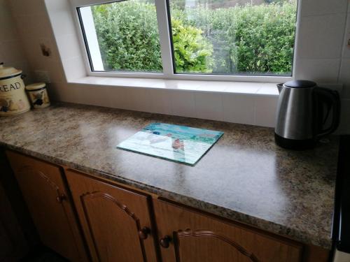 a book on a kitchen counter with a window at Atlantic Way Farmhouse in Lahinch