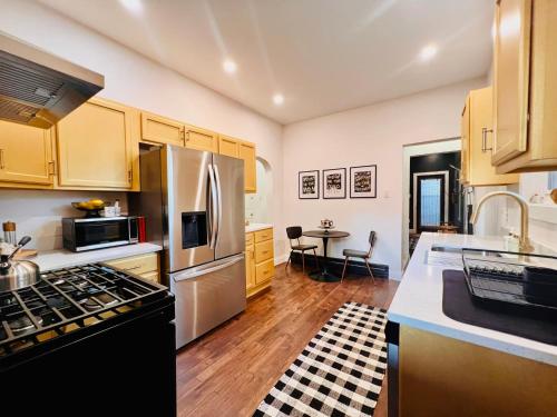 a kitchen with stainless steel appliances and a table at Drifterland Artistic Retreat in Lawrenceville in Pittsburgh