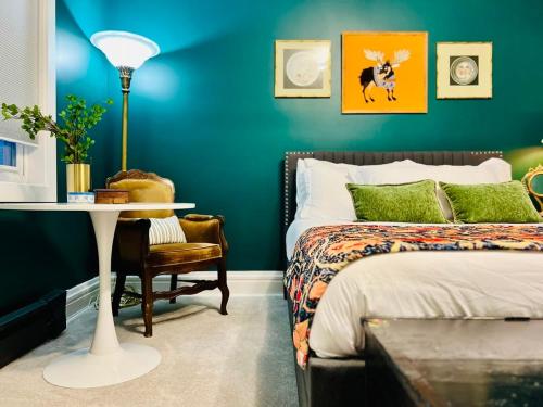 a bedroom with a bed and a table and a chair at Drifterland Artistic Retreat in Lawrenceville in Pittsburgh