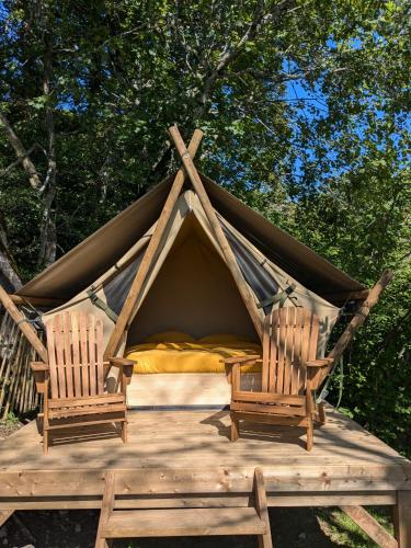 une tente avec 2 chaises sur une terrasse en bois dans l'établissement The Mountain Nest, à La Pirraz