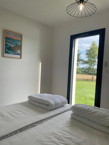 a bedroom with two beds and a large window at Villa de Groupe avec Piscine, Jacuzzi et Vue Nature in Pierric