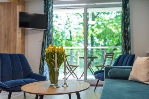 a living room with a vase of flowers on a table at VacationClub - Podgórzyńska 6A Apartament 5 in Jelenia Góra