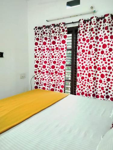 a bedroom with a bed and a red curtain at Coorg Sunway home stay in Madikeri