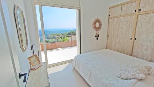 Sant Cebrià de VallaltaにあるCasa Blancaのベッドと大きな窓のある寝室