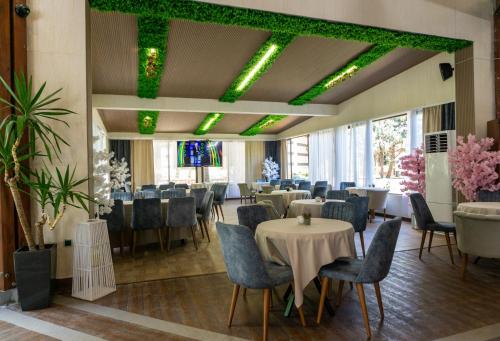 a banquet hall with tables and chairs and green lights at Emerald Beach Resort & Spa in Ravda